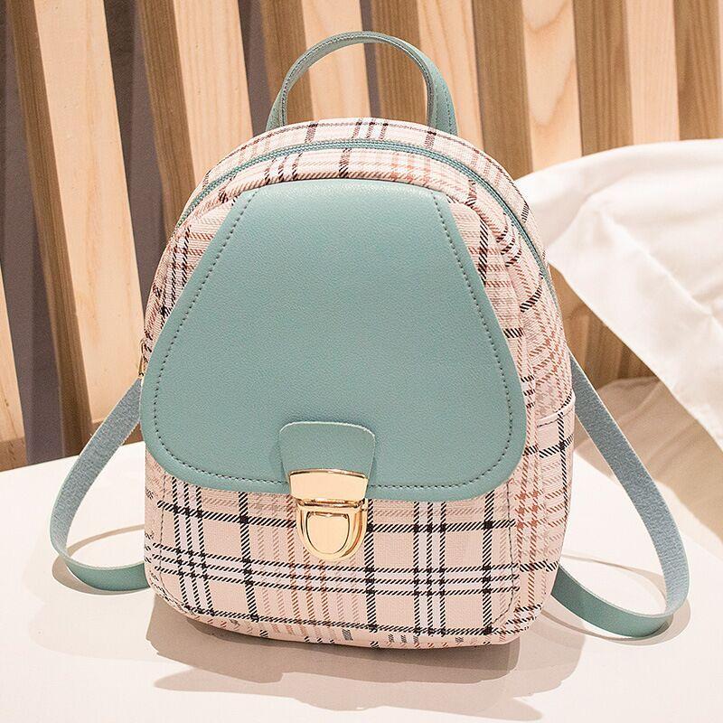 Small backpack with plaid pattern and teal accents on a neutral background