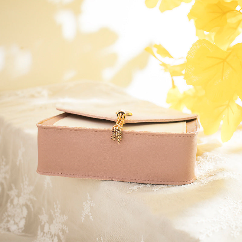 Pink jewelry box with gold clasp on a soft, blurred background