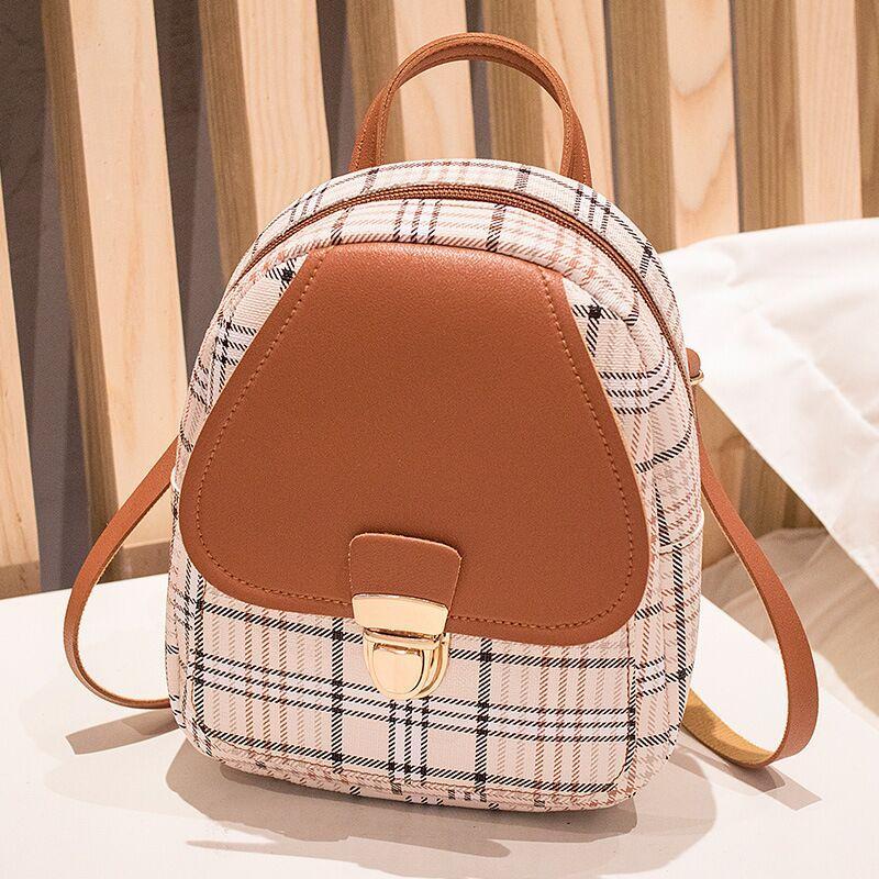 Backpack with plaid pattern and brown accents on a neutral background