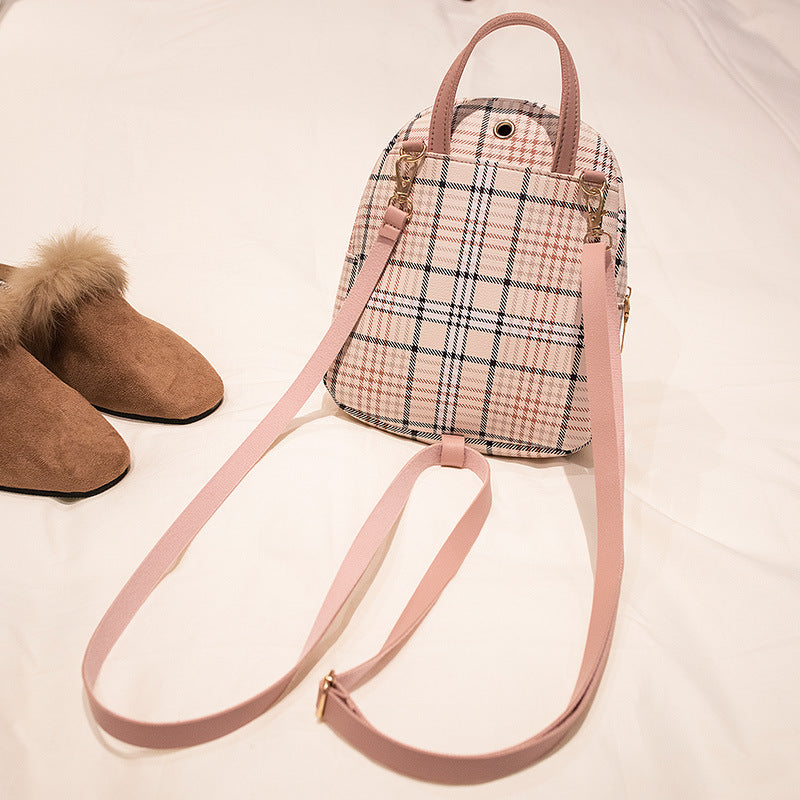Plaid bag with pink strap and brown shoes on a light background