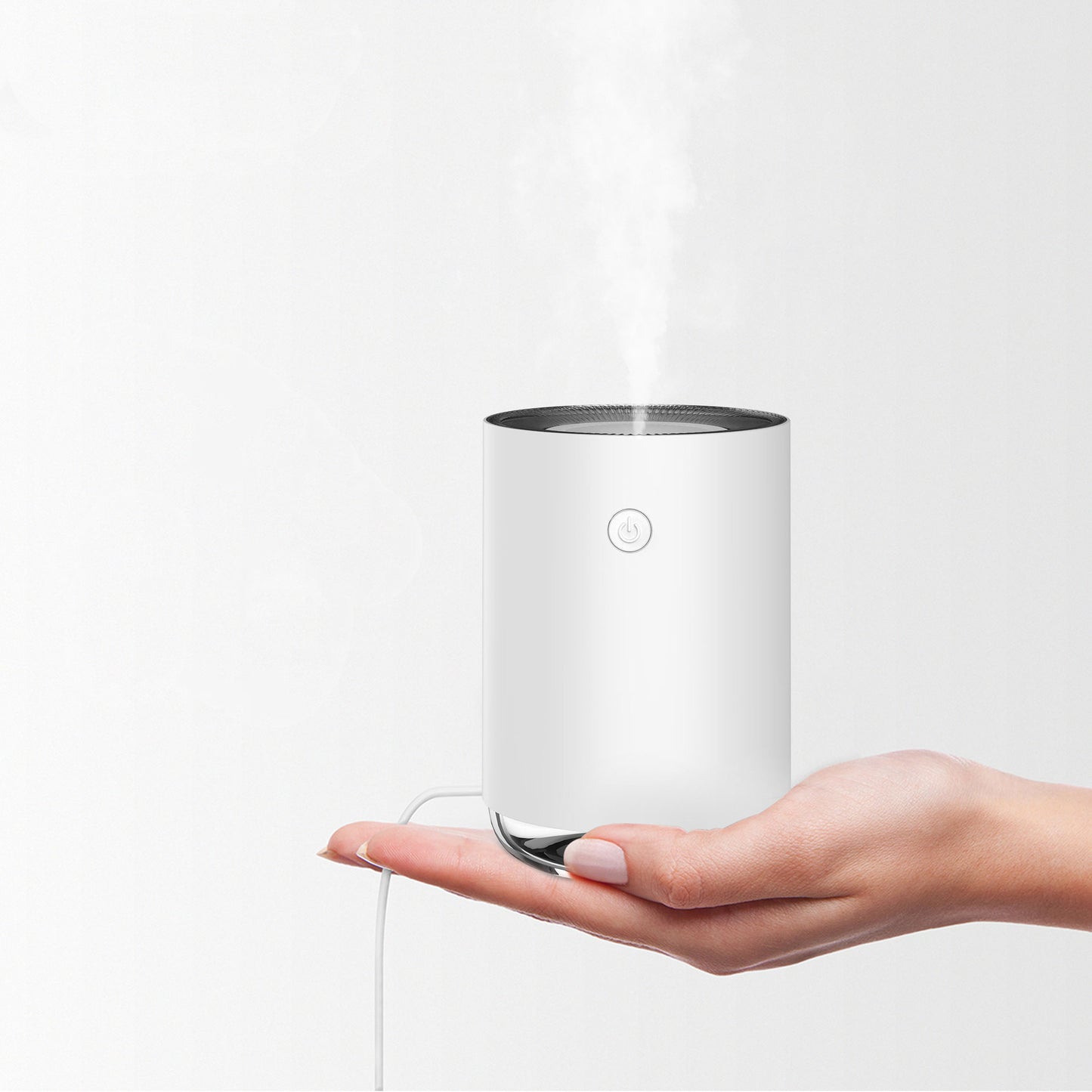 Hand holding a white cylindrical device with steam coming out on a light gray background