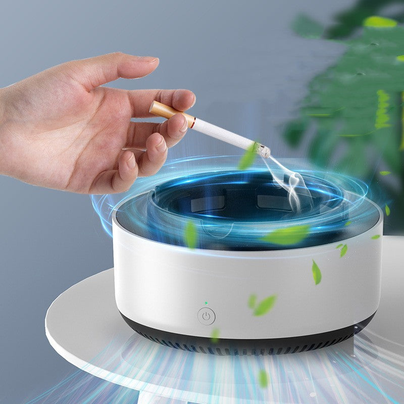 Hand holding a cigarette over a white ashtray with blue light and green leaves.