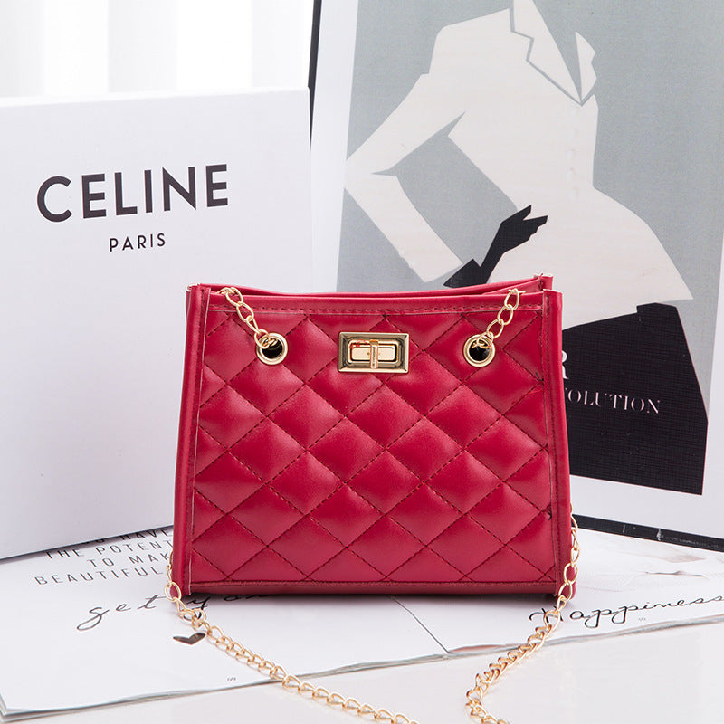 Red quilted handbag with gold chain on a magazine with Celine branding.