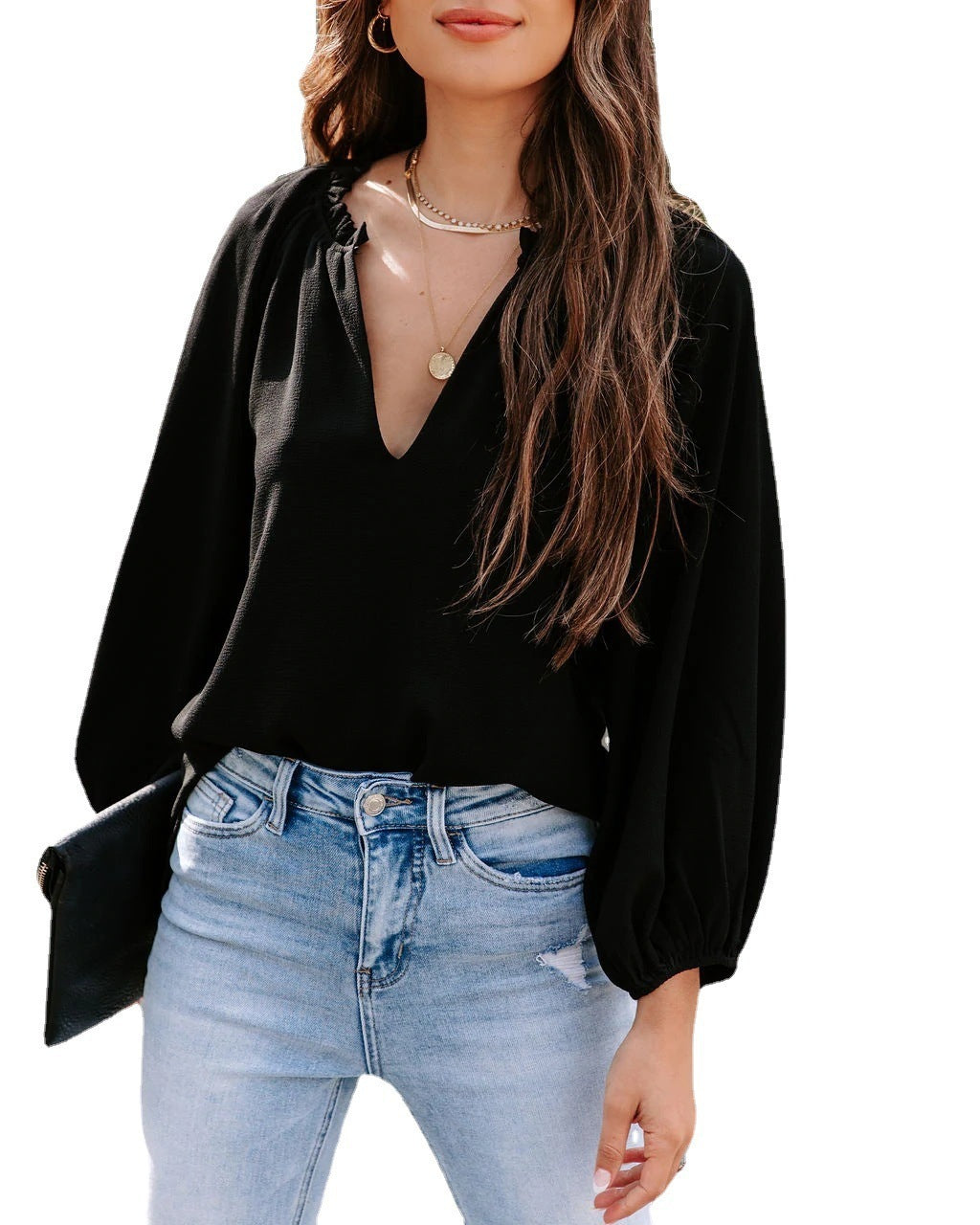 Person wearing a black blouse and light blue jeans on a white background