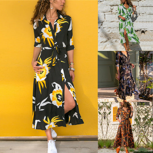 Woman wearing a black floral dress with yellow flowers against a yellow wall.