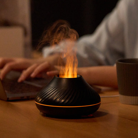 Black and orange diffuser emitting steam on a wooden table with a blurred background