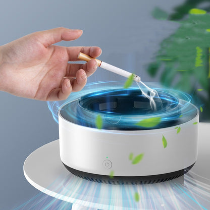 Hand holding a cigarette over a white ashtray with blue light and green leaves.